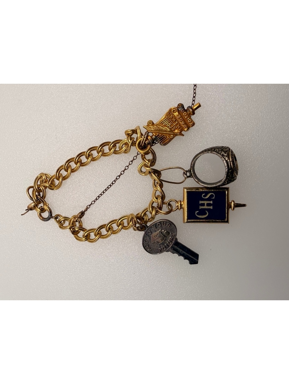 Gold tone charm bracelet with key and CHS charm
